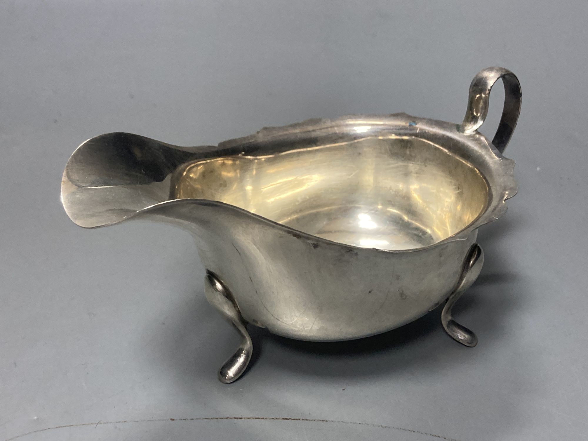 A late 19509s silver sauceboat on stand, Viners Ltd, Sheffield, 1958/9 and a George V silver porringer,